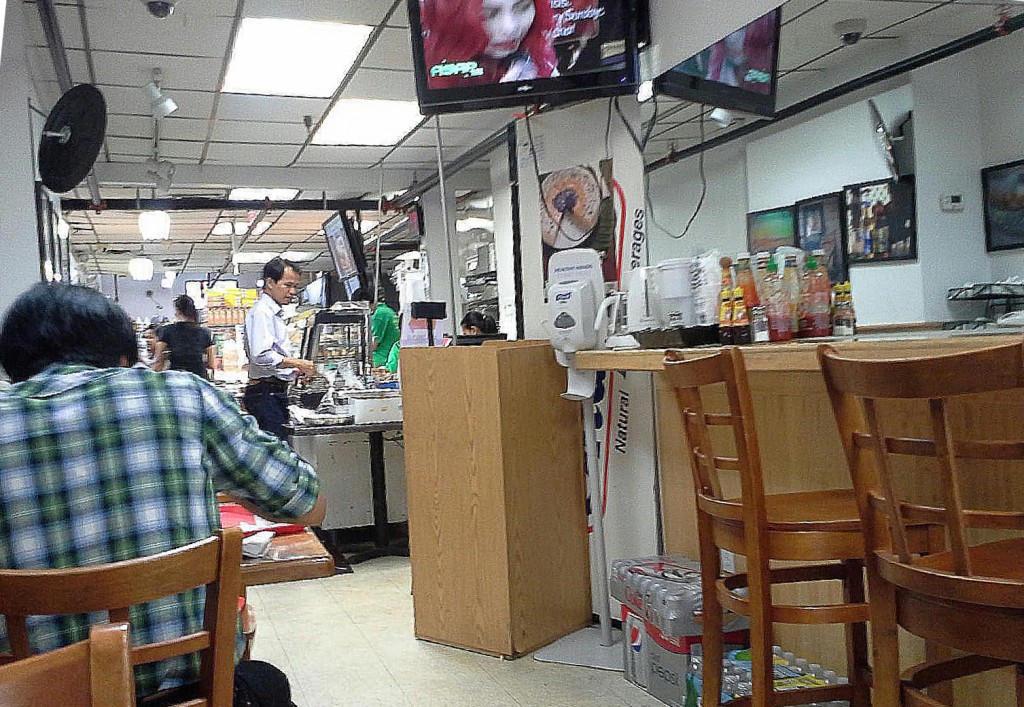 Customers in the cafe area at Phil Am Food Market can watch television shows and movies in Tagalog. Photo by Lai Wo.