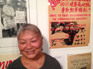 Lisa Yee was involved in the protests at Confucius Plaza, documented in the poster on the wall next to her. Photo by Esther Wang.