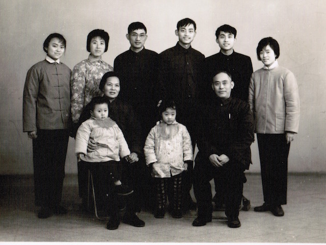 I was four years old, and my brother was three. The back row from left to right: my auntie, my parents, my younger uncle, my older uncle and his newlywed wife. My grandparents sat in the front row. My brother wanted to run away, so my grandma put him on her lap and held his hand. I was the good girl, furtively playing with my coat and exploring my pocket. Photo courtesy the author.